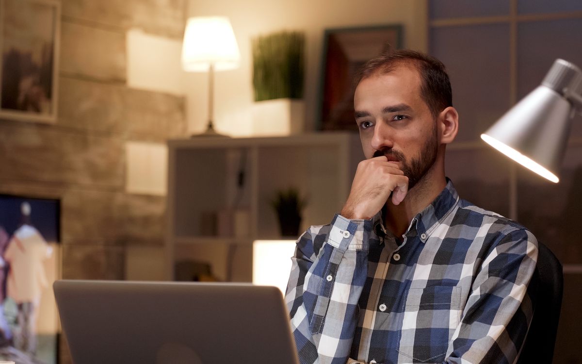 Homem em dúvida olhando para a tela de um notebook
